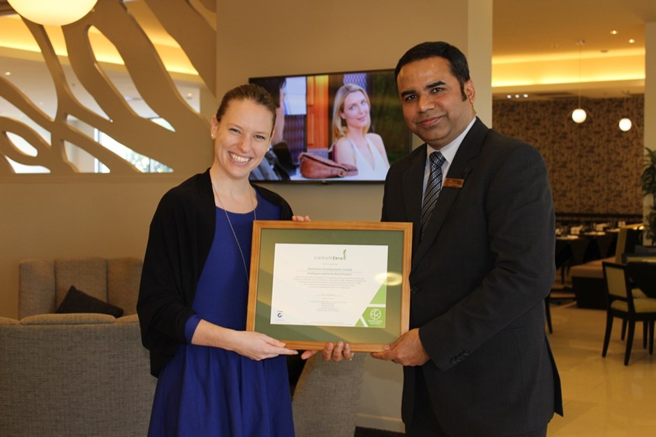 Two people smiling and holding a framed certificate.