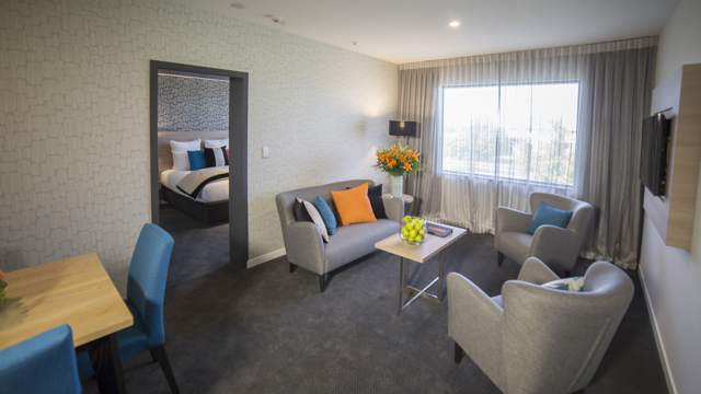 Lounge room with one sofa, two chairs plus dining table and chairs too.