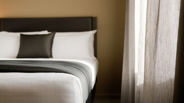 Superior king room shows side of bed next to curtain.