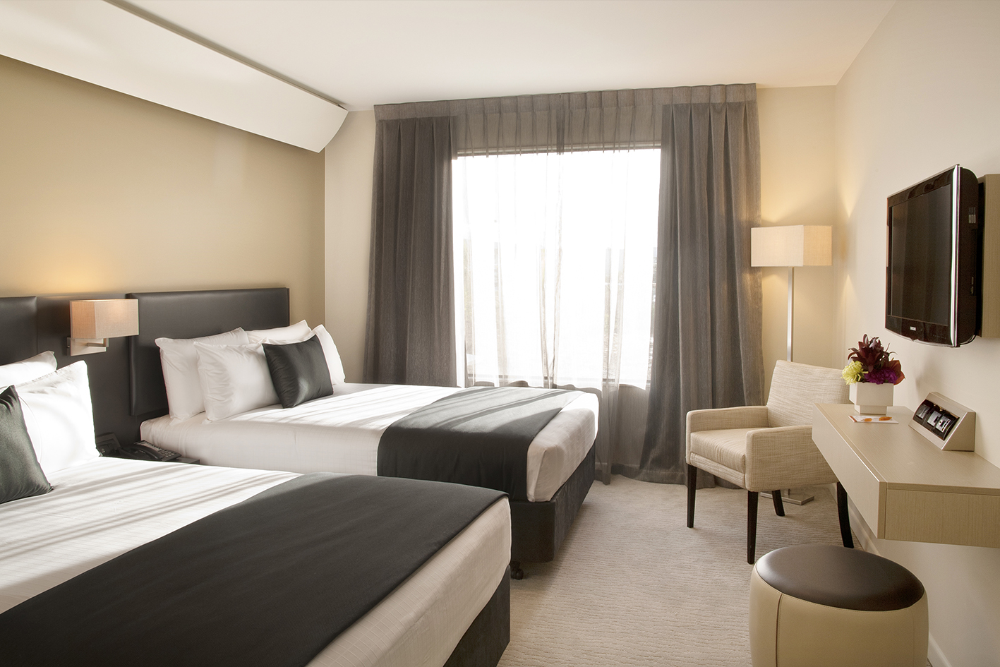 Superior twin room. Two large beds with lounge seat, desk and chair, flatscreen TV, ottoman and lamps