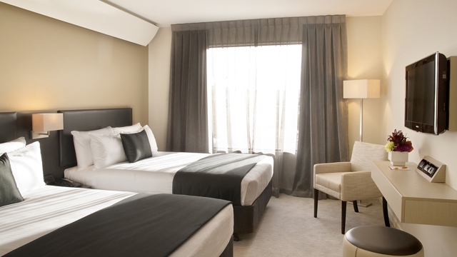 Superior twin room. Two large beds with lounge seat, desk and chair, flatscreen TV, ottoman and lamps