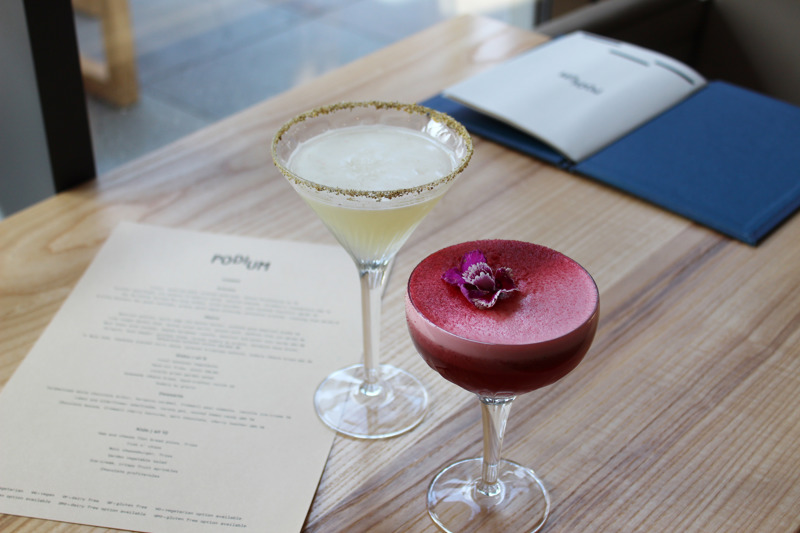 One pink and one lemon cocktail in martini style glasses on table