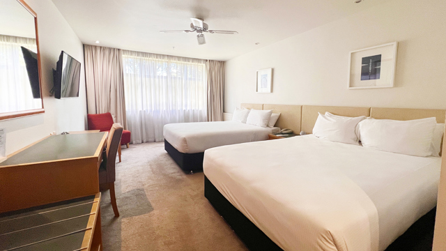 Superior Twin room with 2 Double Beds, desk and armchair by window
