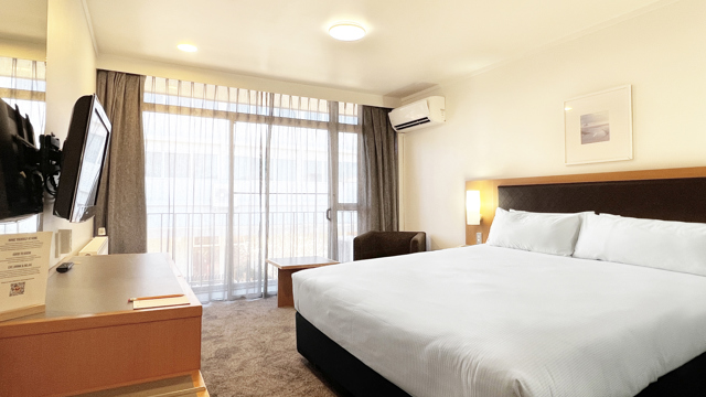 Superior King room with 1 Double Bed, desk, armchair and table by window